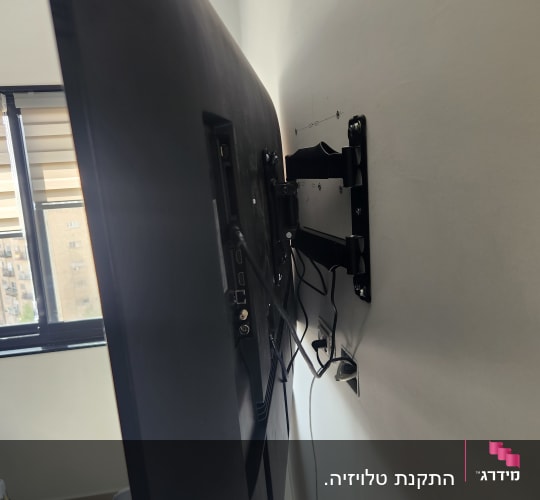 טלוויזיה מותקנת על זרוע מתכווננת על קיר
